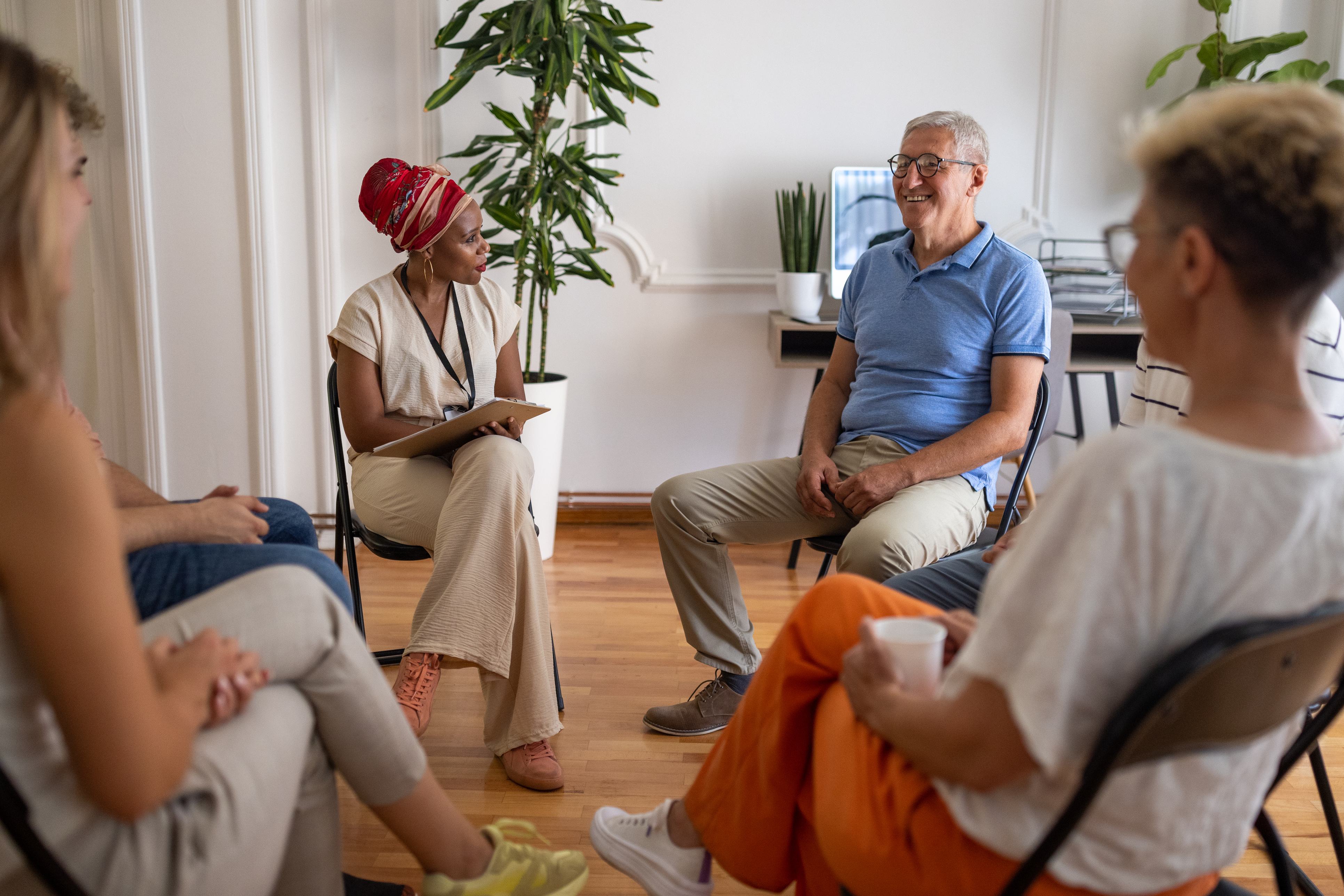 men_and_women_in_a_community_group_talking_and_laughing