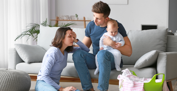 woman_upset_whilst_man_holding_baby_sits_and_listens