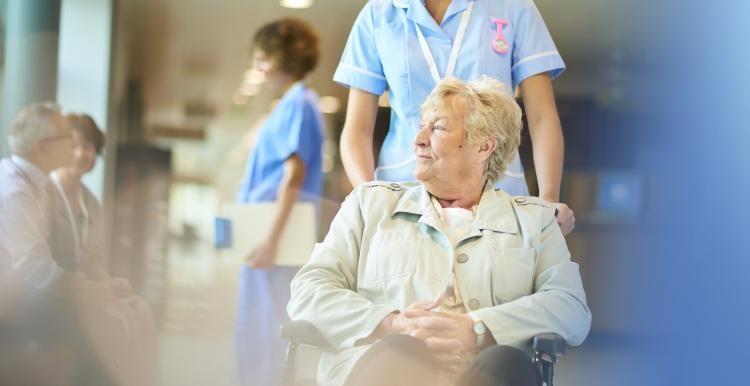 woman_being_pushed_in_a_wheechair_by_a_nurse