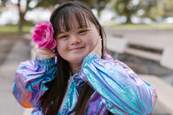 Girl_smiling_wearing_a_flower