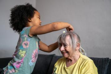 Elderly_woman_having_her_hair_played_with_by_a_little_girl
