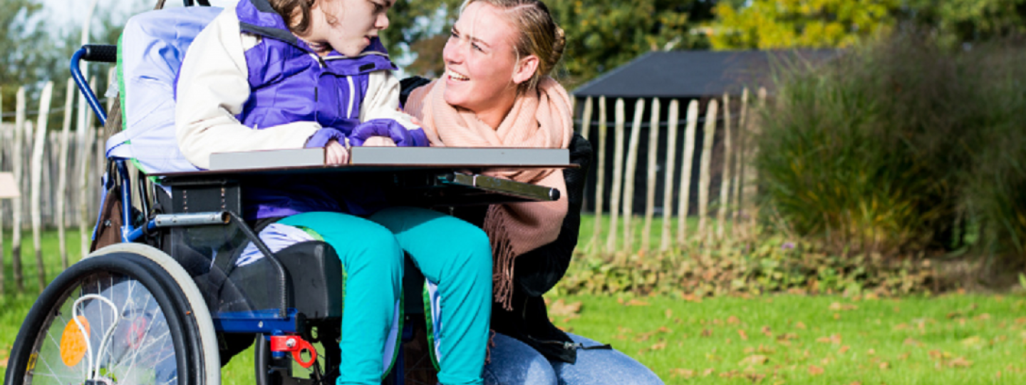 dIsabled_young_girl_in_a_wheelchair_with_female_carer